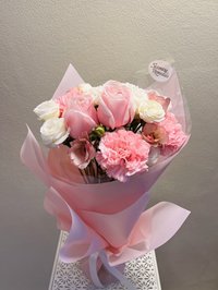 Pink and white bouquet with roses and carnations wrapped in pink paper