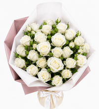 White rose bouquet wrapped in pink and white paper with a white ribbon