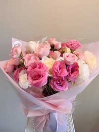 Pink and white rose bouquet with lilies and orchids wrapped in pink paper