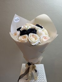 Bouquet of ivory and black roses wrapped elegantly with a ribbon