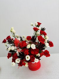 Red and white flower bouquet with roses in a decorative container