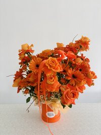 Vibrant orange bouquet with roses and gerberas in an orange box