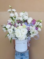 Bouquet of white roses, purple lilies, and orchids in a white hat box