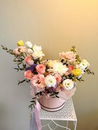 Elegant bouquet with pink roses, white lilies, and purple orchids in a pastel arrangement