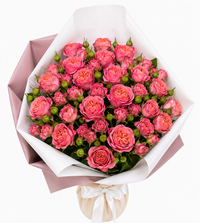 Pink rose bouquet elegantly wrapped in soft paper with a white ribbon