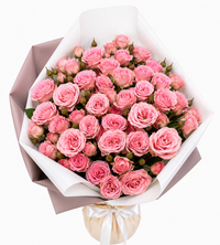 Bouquet of pink roses wrapped in elegant paper with a ribbon