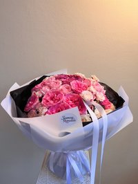 Pink and white rose bouquet with dark wrapping and white ribbons