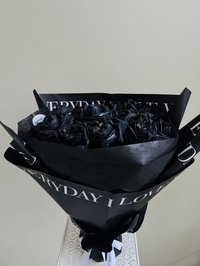 Bouquet of black roses wrapped in black paper with white lettering