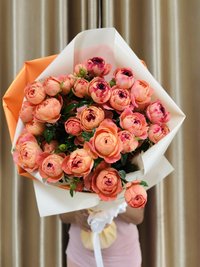 Bouquet of orange spray roses wrapped in white and orange paper